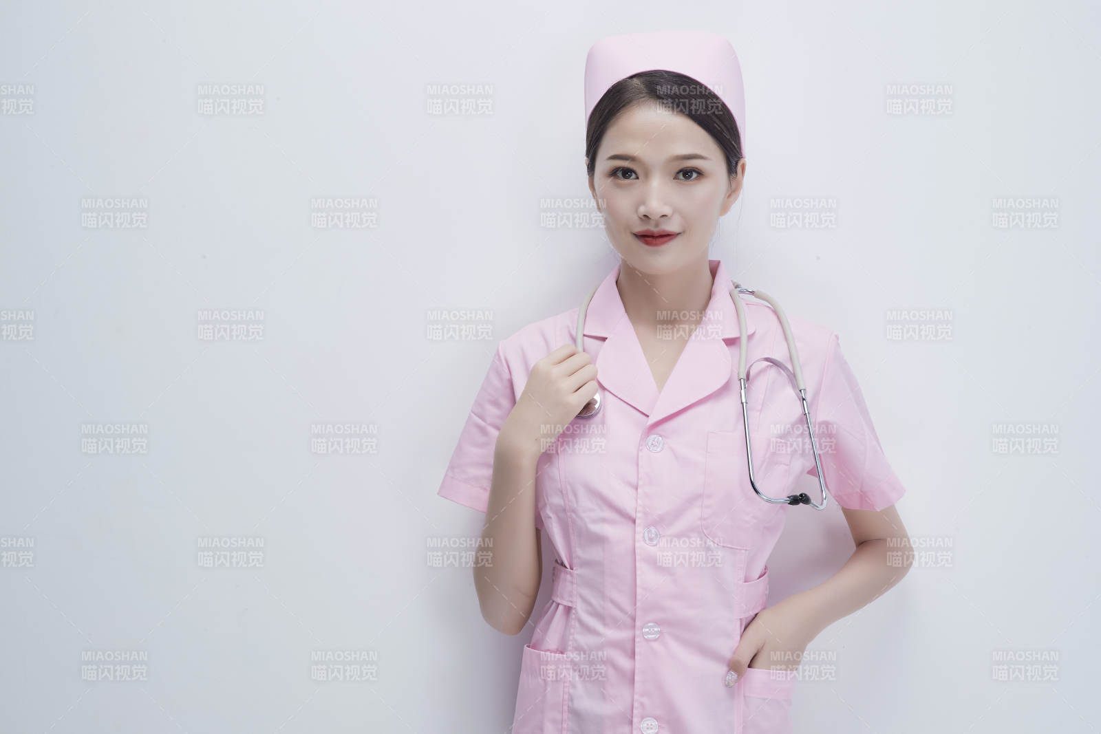 身穿粉色護士服佩戴聽診器的女性醫護人員