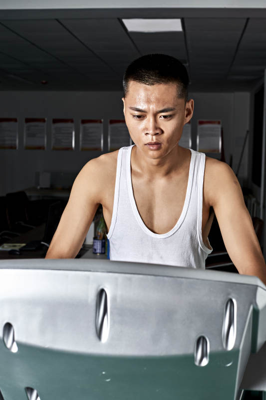 在室内用跑步机进行锻炼的亚洲健身男士形象