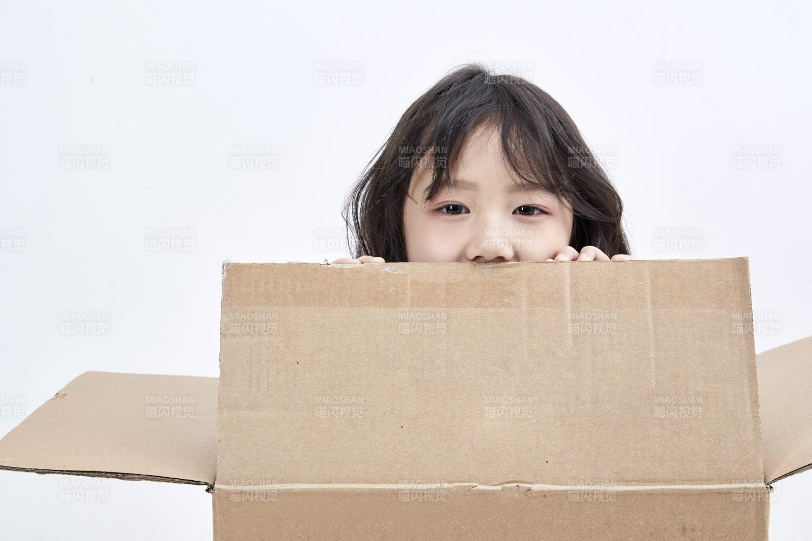 躲在紙箱中玩耍的調皮可愛亞洲小女孩兒童