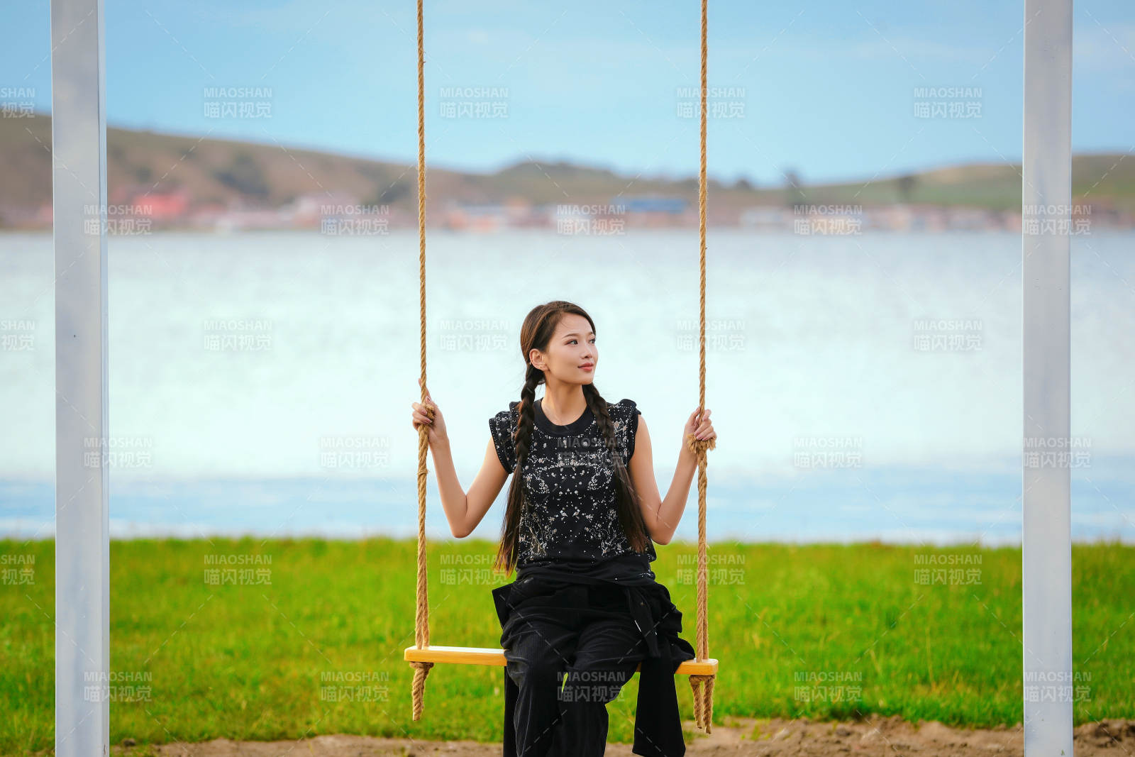 草原湖畔夕阳下荡秋千的亚洲少女
