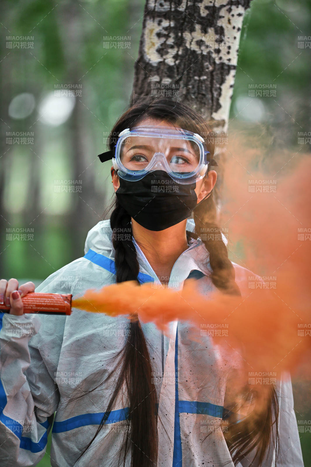 手執彩煙身穿防護服裝的女性醫療人員