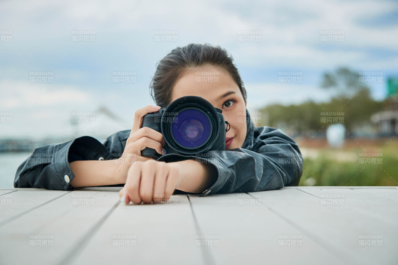 戶外湖畔進行拍攝的亞洲青年女性攝影師