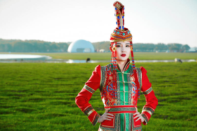 草原上穿着蒙古族传统服饰的亚洲年轻美少女