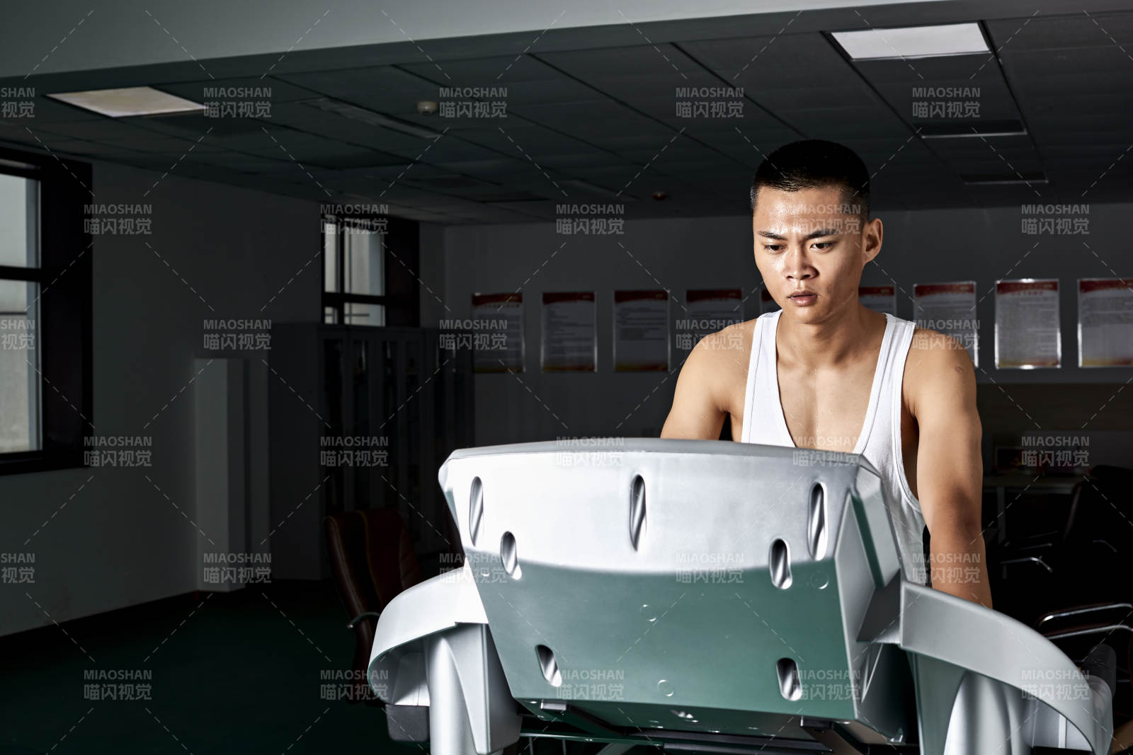 在室内用跑步机进行锻炼的亚洲健身男士形象