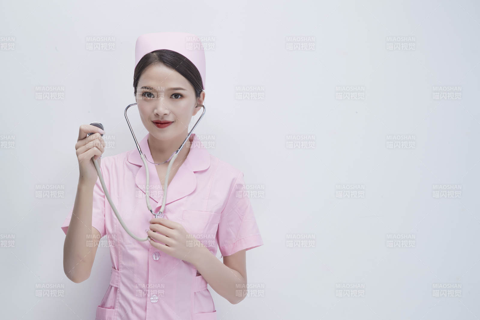 身穿粉色護士服佩戴聽診器的女性醫護人員