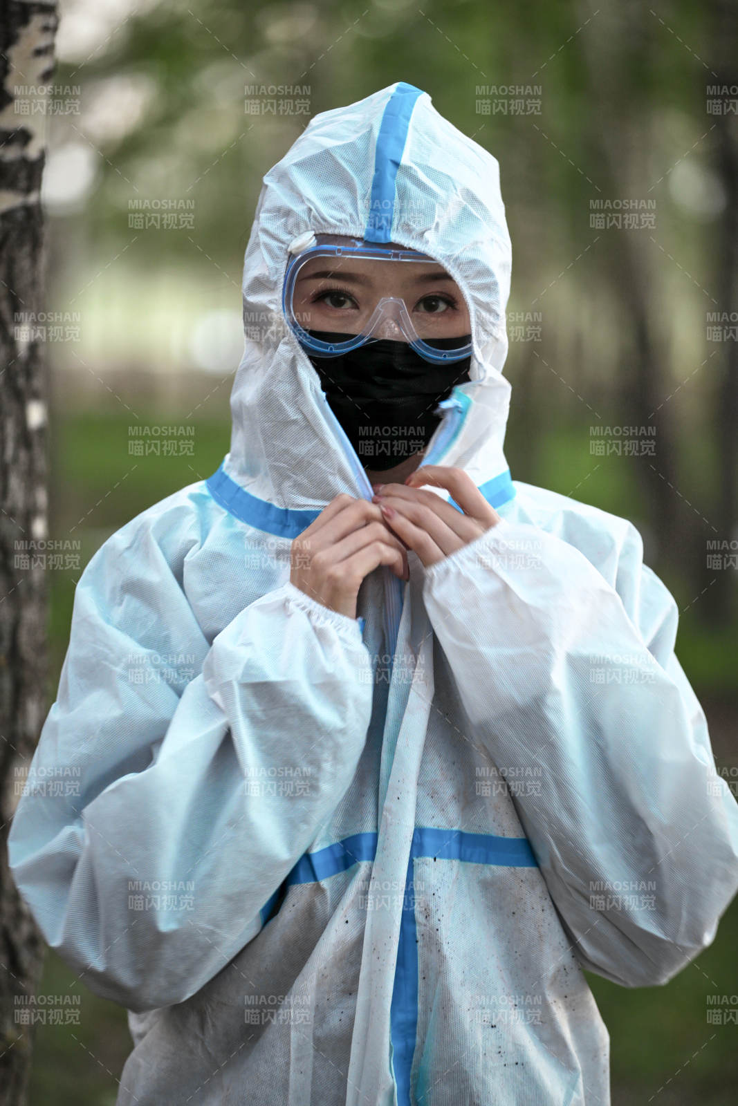 穿白色防护服佩戴护目镜口罩的女性防护人员