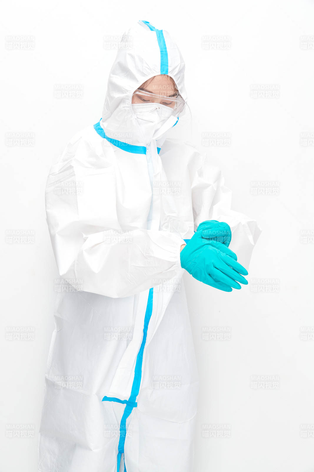 穿白色防护服佩戴护目镜口罩的女性医疗人员