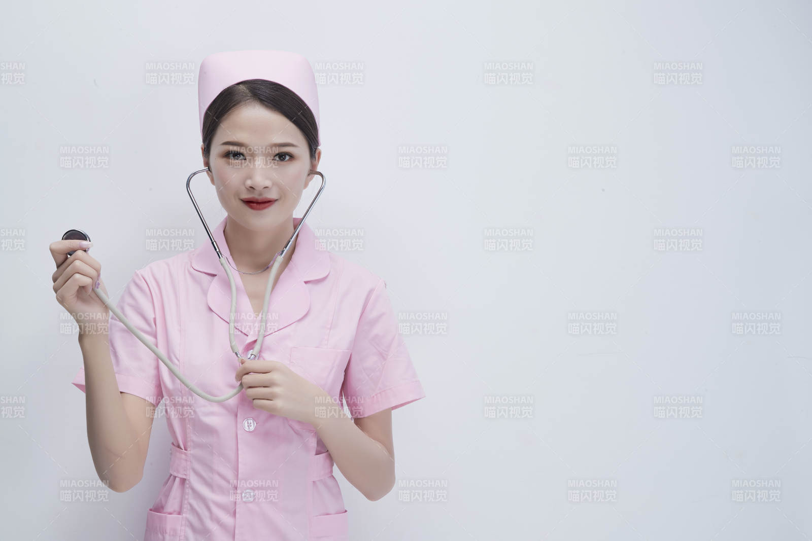 身穿粉色護士服佩戴聽診器的女性醫護人員