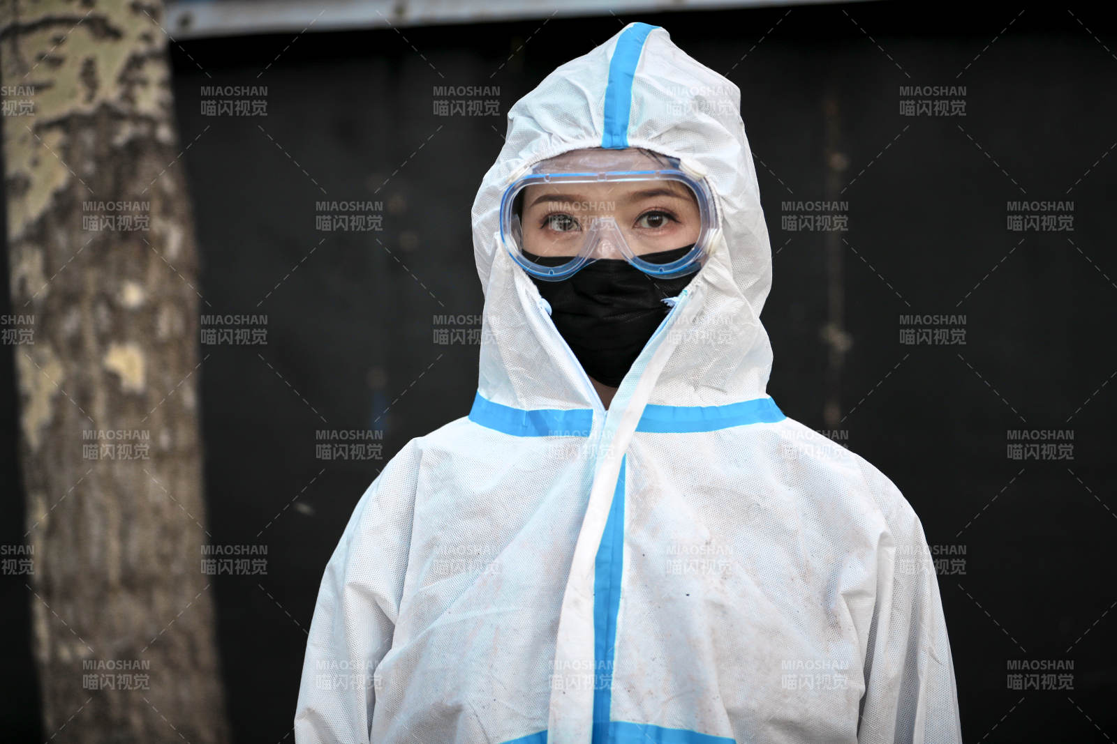 穿白色防护服佩戴护目镜口罩的女性防护人员