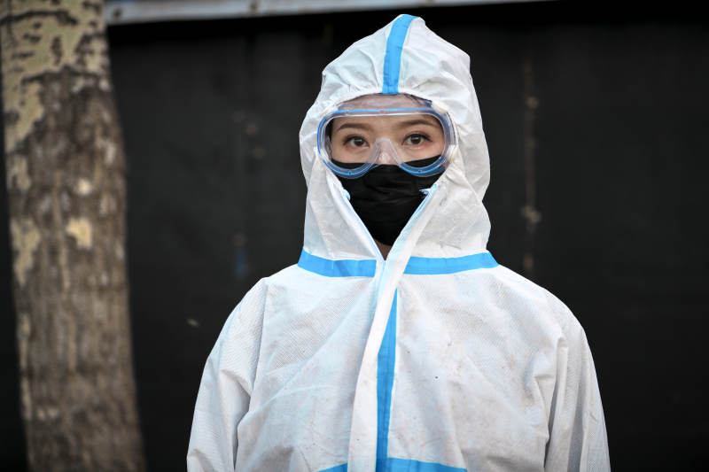 穿白色防护服佩戴护目镜口罩的女性防护人员