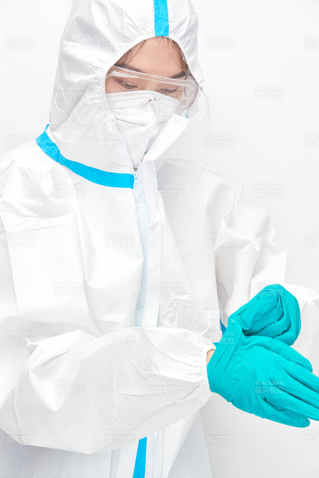 穿白色防护服佩戴护目镜口罩的女性医疗人员