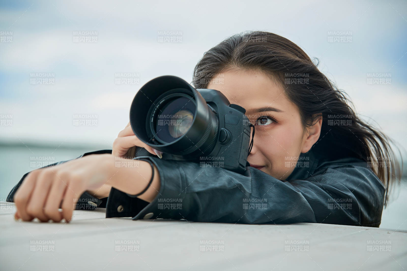 户外湖畔进行拍摄的亚洲青年女性摄影师