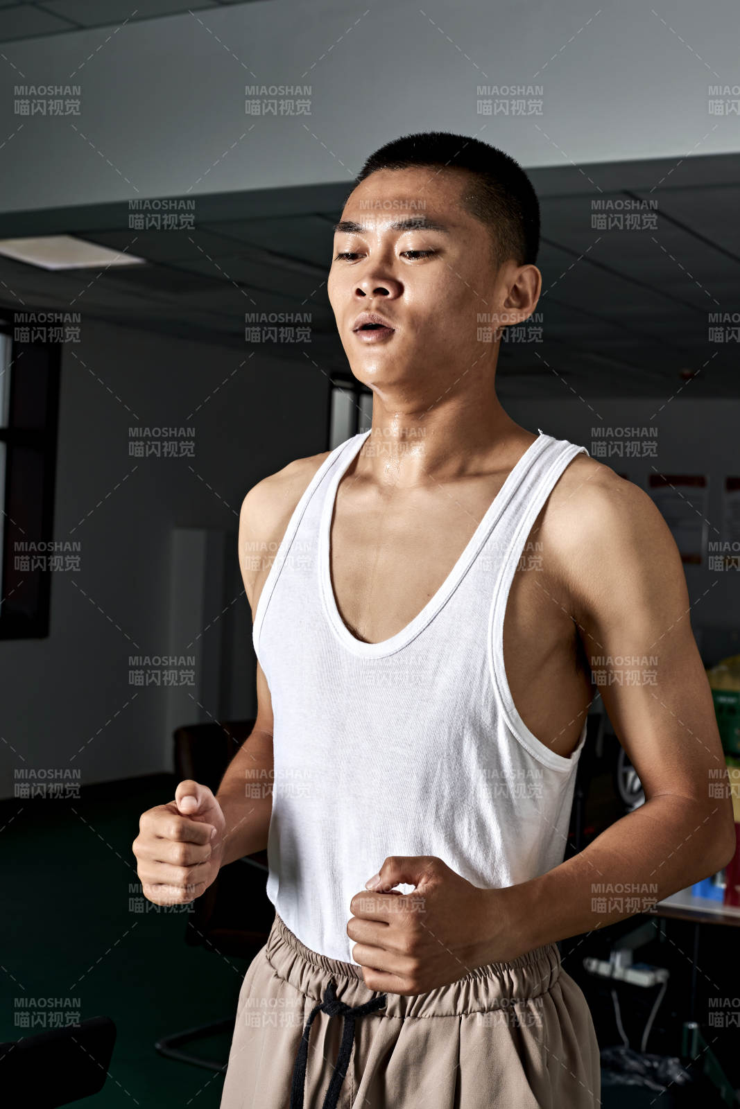 在室內(nèi)用跑步機(jī)進(jìn)行鍛煉的亞洲健身男士形象