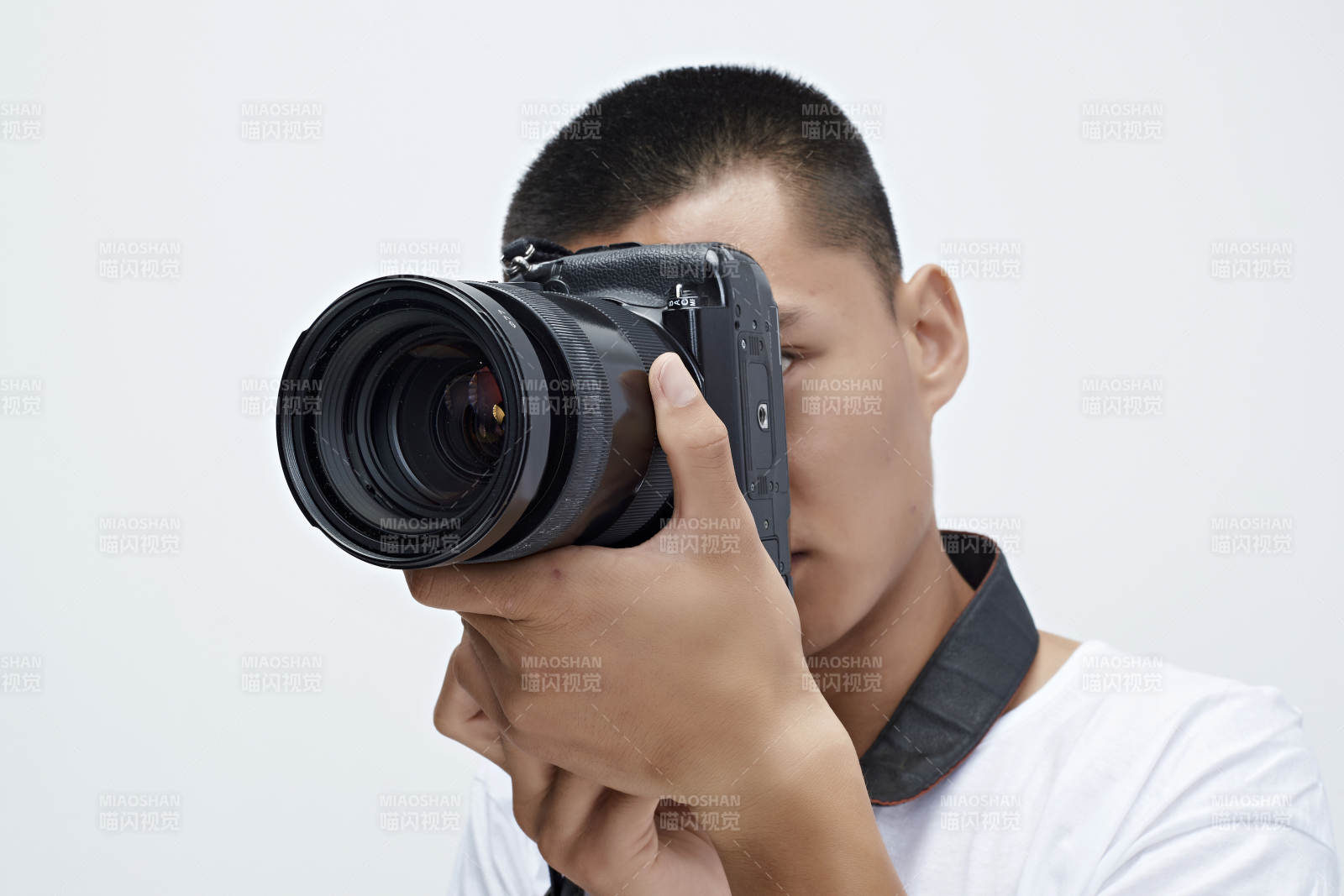 白色背景下手持照相機的亞洲男性攝影師