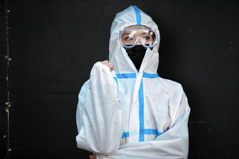 穿白色防护服佩戴护目镜口罩的女性防护人员