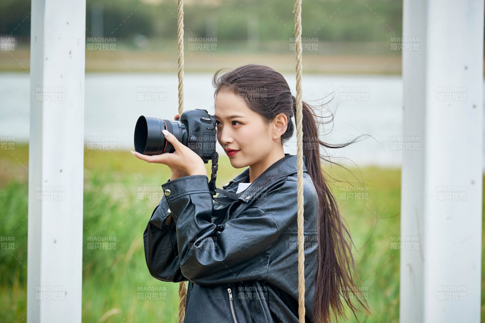 戶外湖畔進行拍攝的亞洲青年女性攝影師