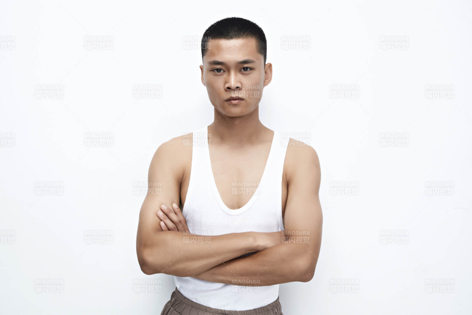 白色背景下展示健身預備拉伸動作的亞洲男性