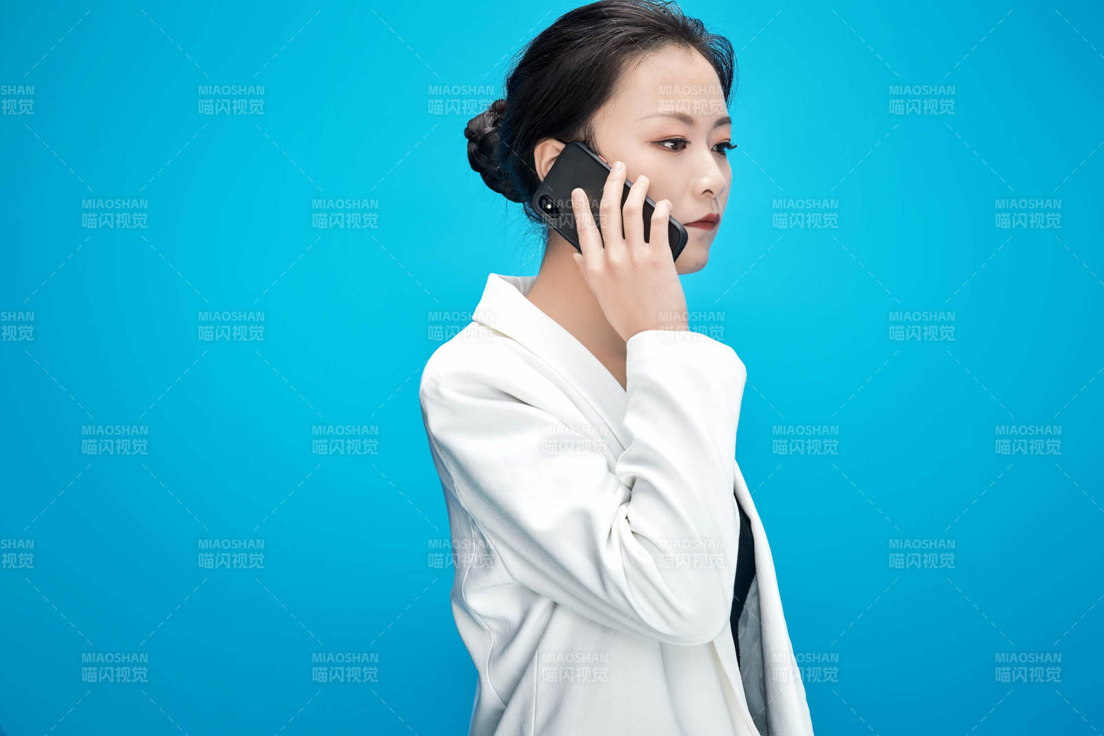 身穿西服拿着手机与文件夹的亚洲商务女士