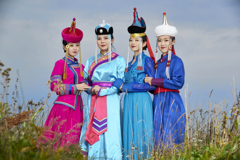 草原上穿着蒙古族传统服饰的年轻蒙族姐妹