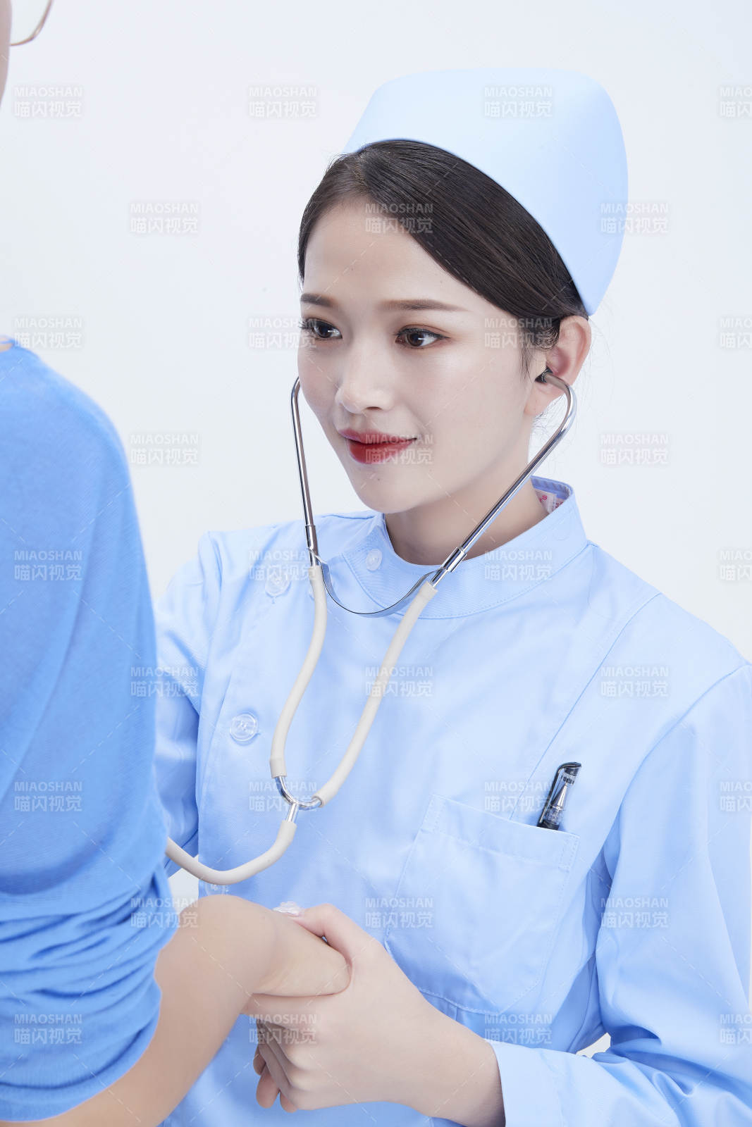 佩戴聽診器的女性醫護人員為患者聽診檢查