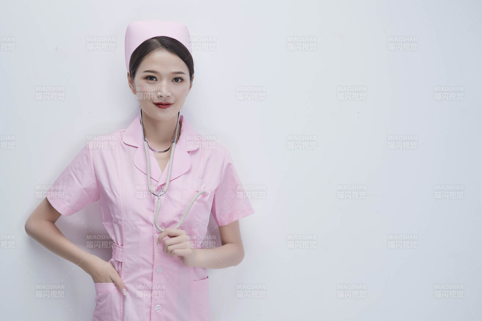 身穿粉色護士服佩戴聽診器的女性醫護人員