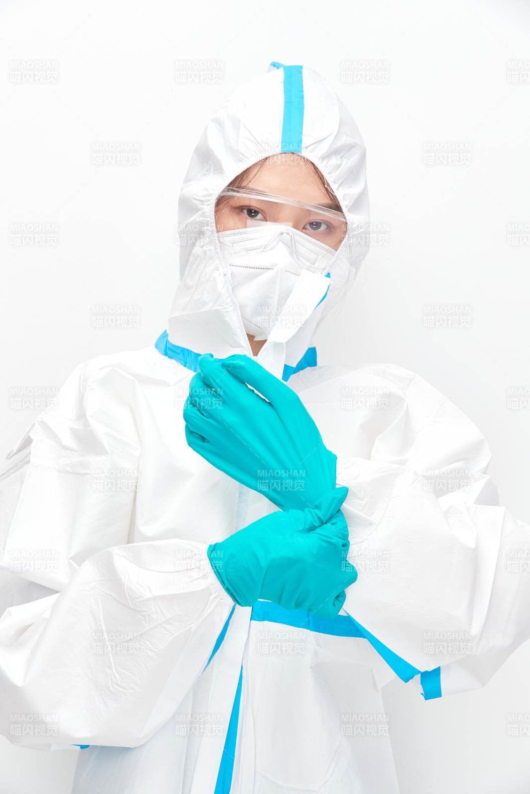 穿白色防护服佩戴护目镜口罩的女性医疗人员