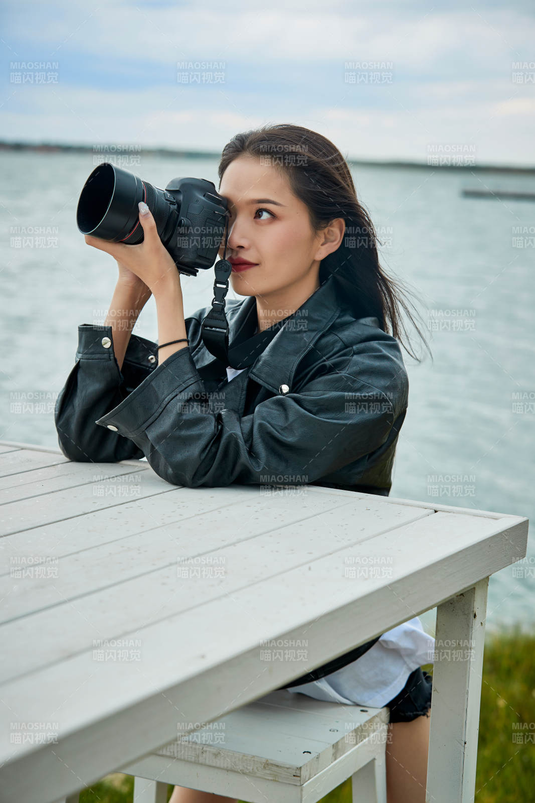 户外湖畔进行拍摄的亚洲青年女性摄影师