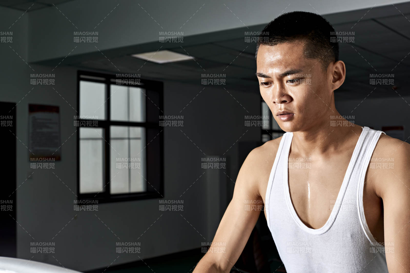 在室內(nèi)用跑步機(jī)進(jìn)行鍛煉的亞洲健身男士形象