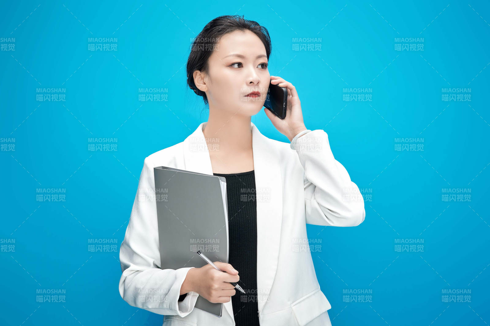 身穿西服拿著手機與文件夾的亞洲商務女士