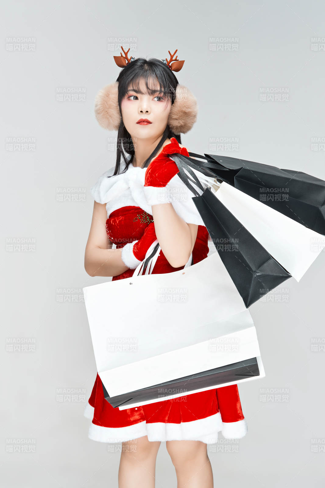 身穿圣誕服飾手提購物袋性感可愛的圣誕女郎