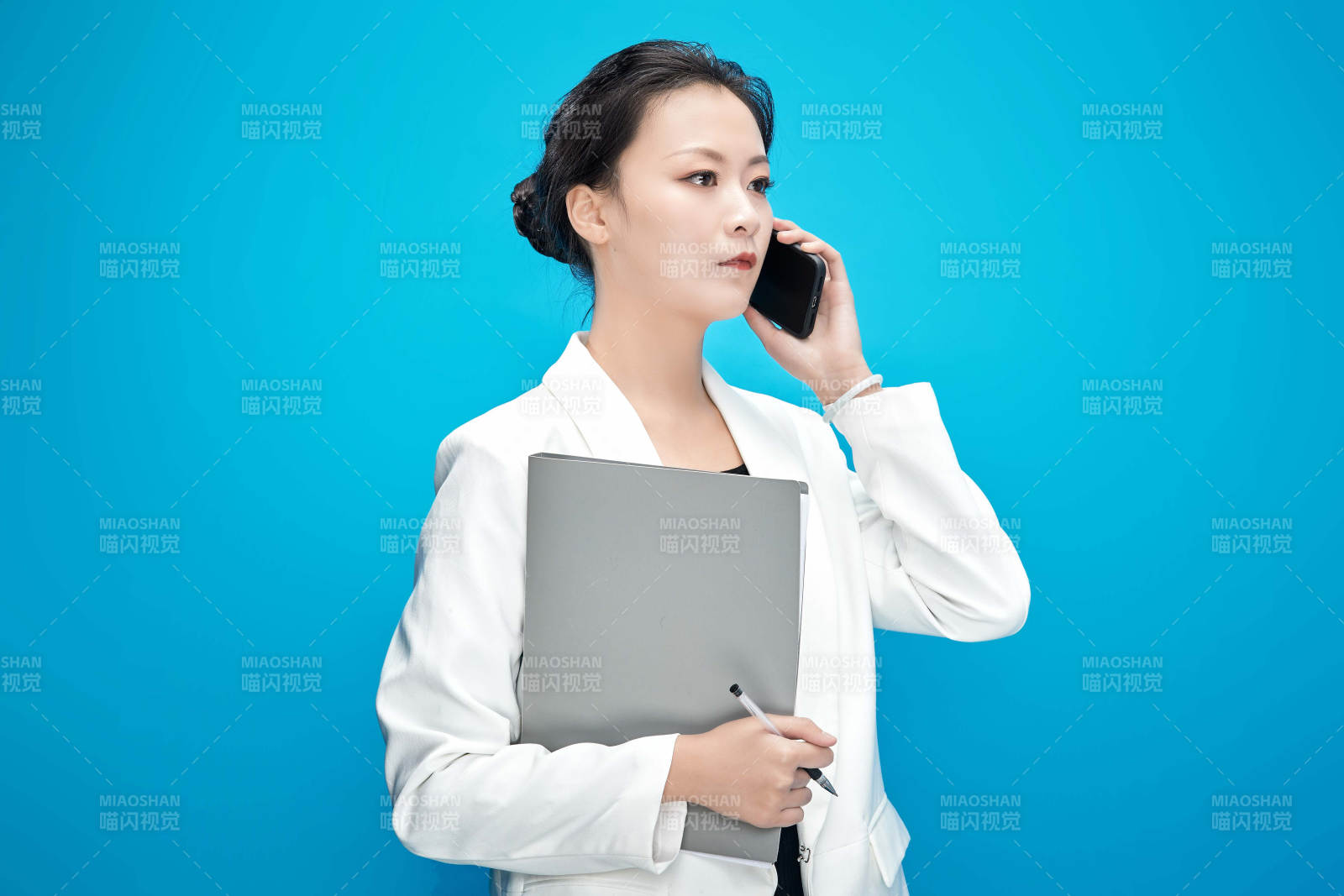 身穿西服拿著手機與文件夾的亞洲商務女士