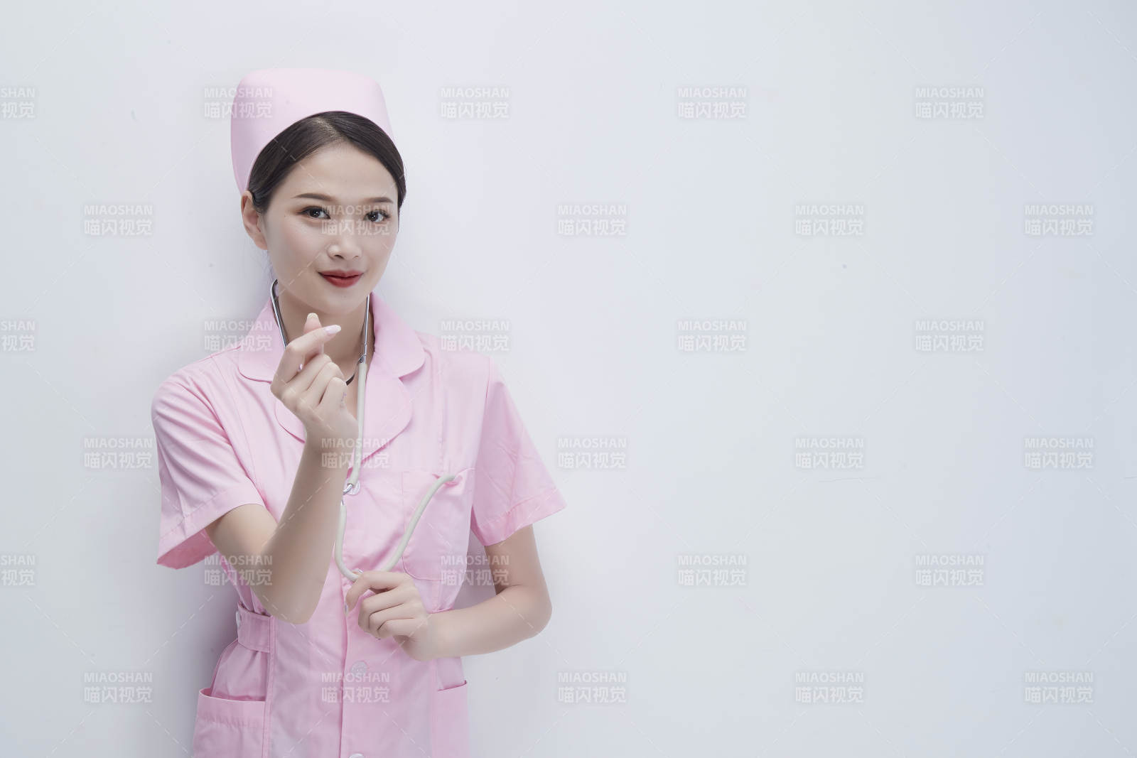 身穿粉色護士服佩戴聽診器的女性醫護人員