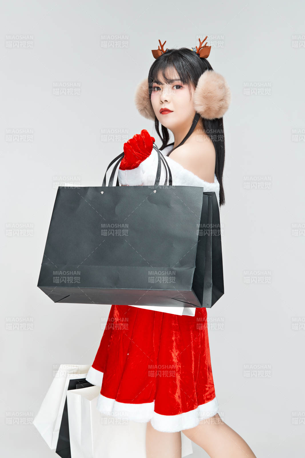 身穿圣誕服飾手提購物袋性感可愛的圣誕女郎