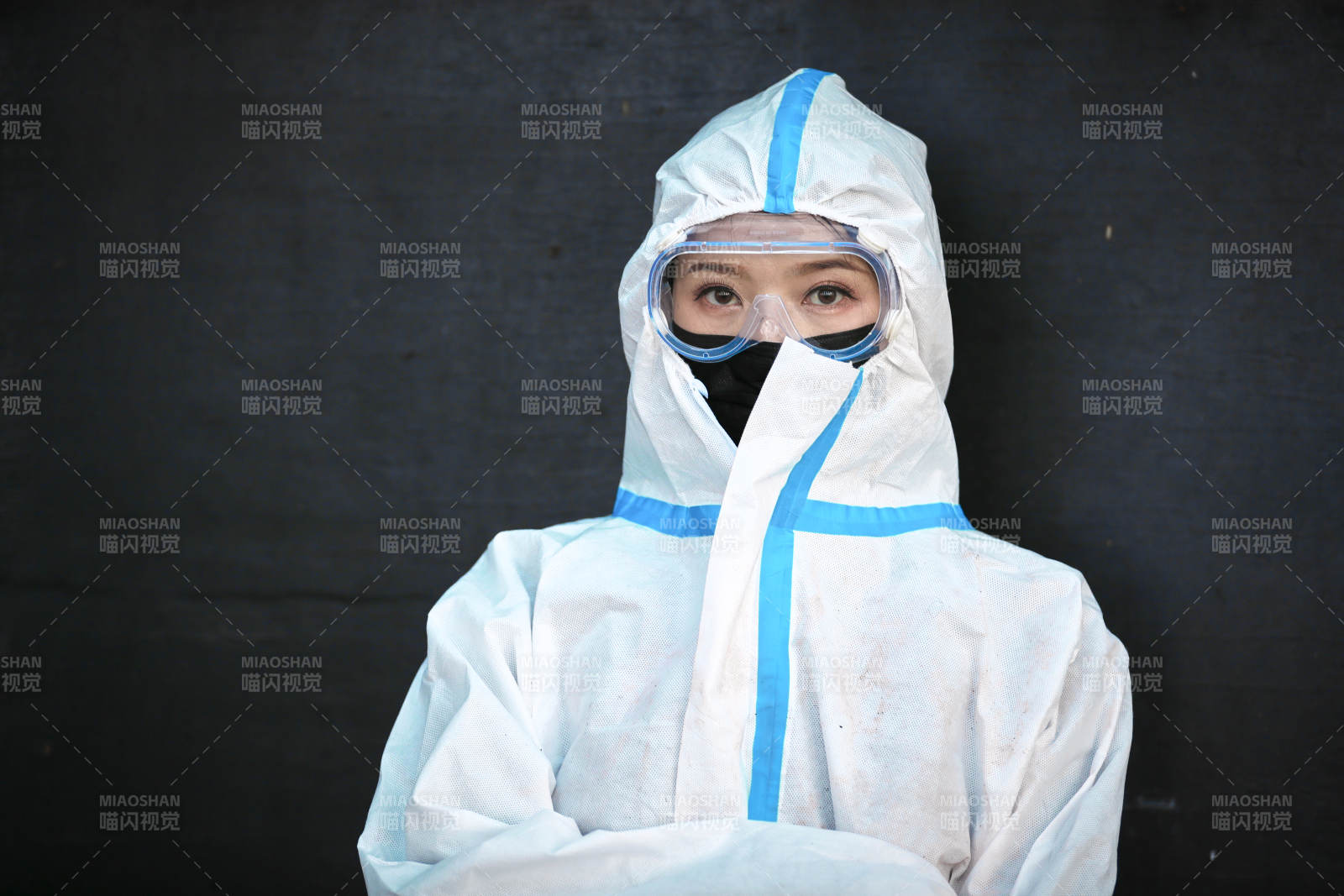 穿白色防護(hù)服佩戴護(hù)目鏡口罩的女性防護(hù)人員