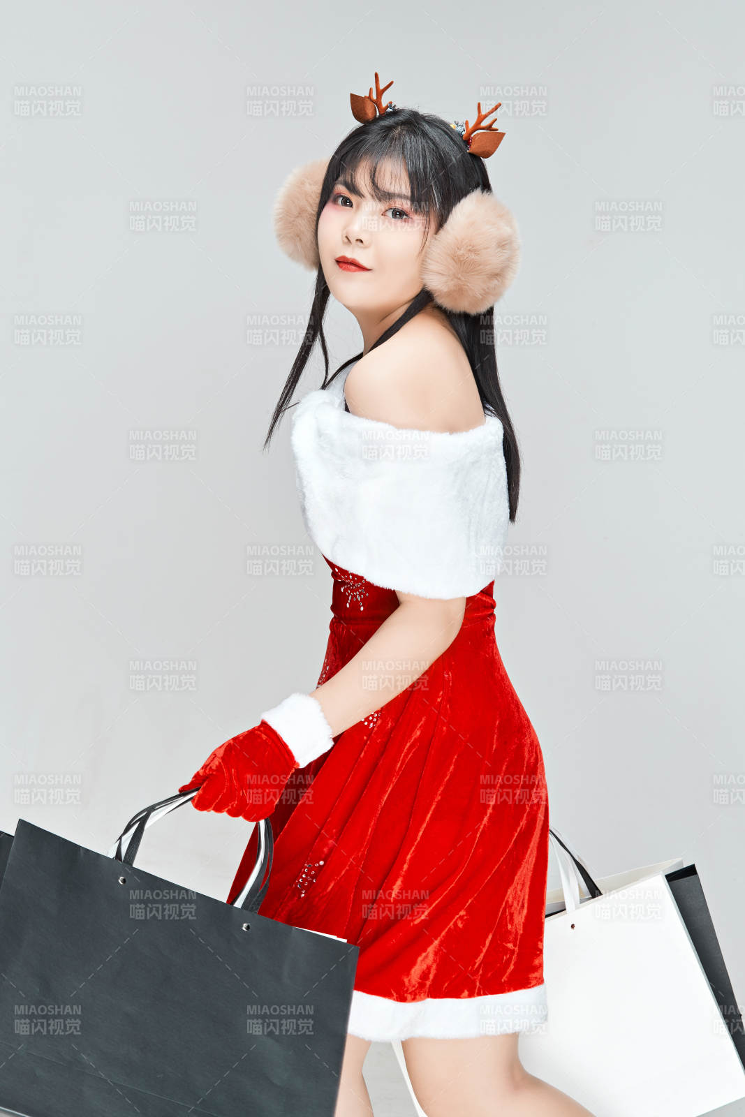 身穿圣誕服飾手提購物袋性感可愛的圣誕女郎