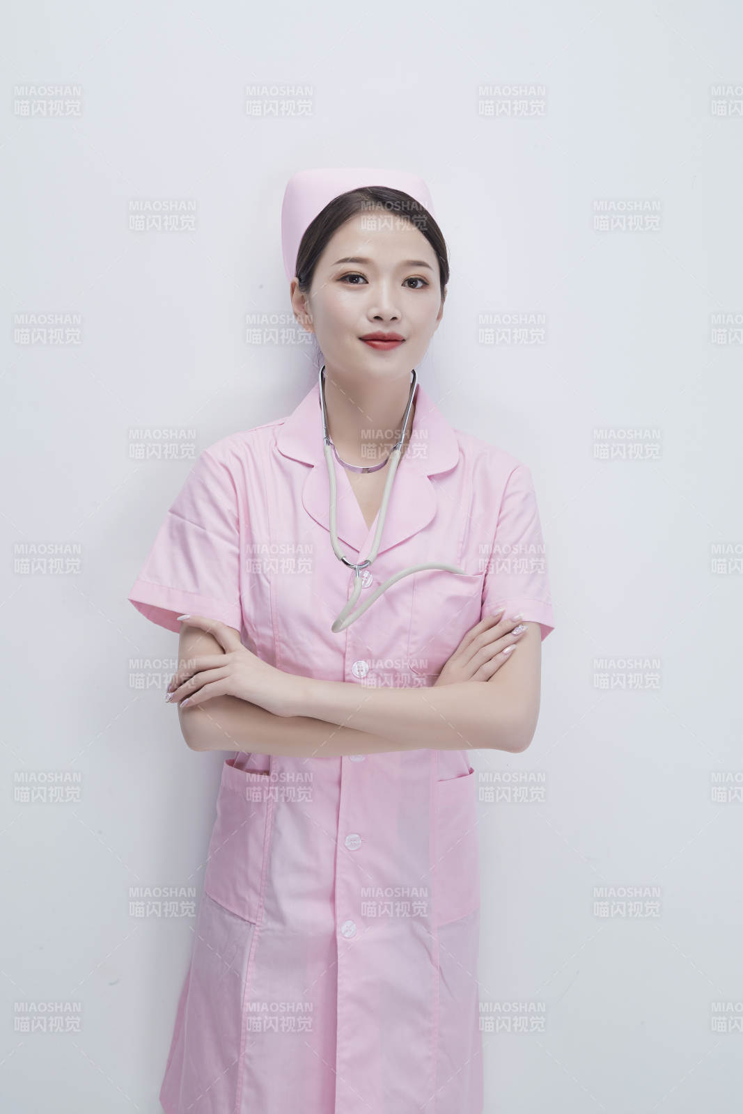 身穿粉色護士服佩戴聽診器的女性醫護人員