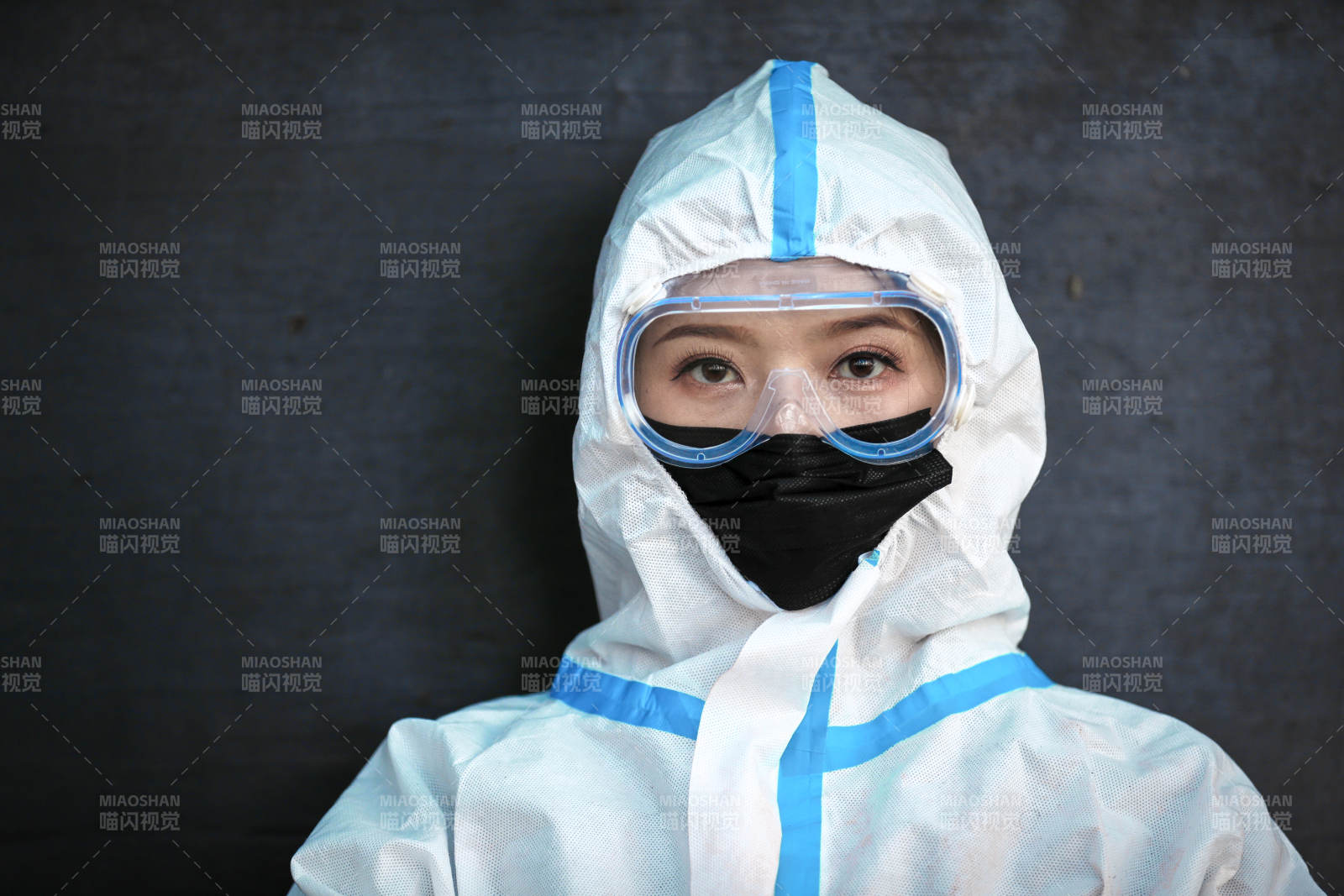 穿白色防護(hù)服佩戴護(hù)目鏡口罩的女性防護(hù)人員