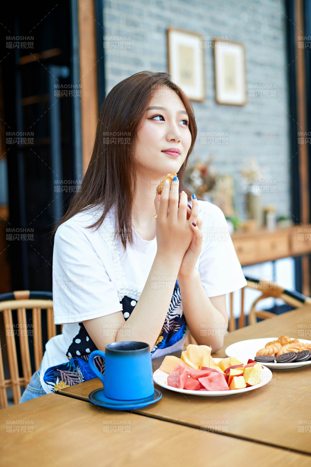 坐在咖啡圖書館吃東西的可愛少女