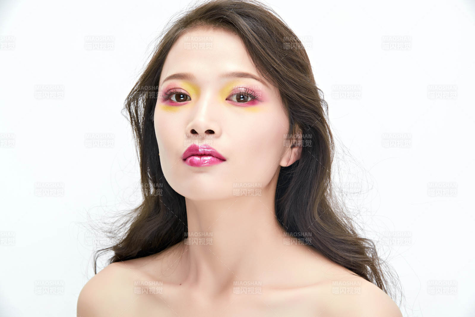 白色背景下棚拍化妝中的美女