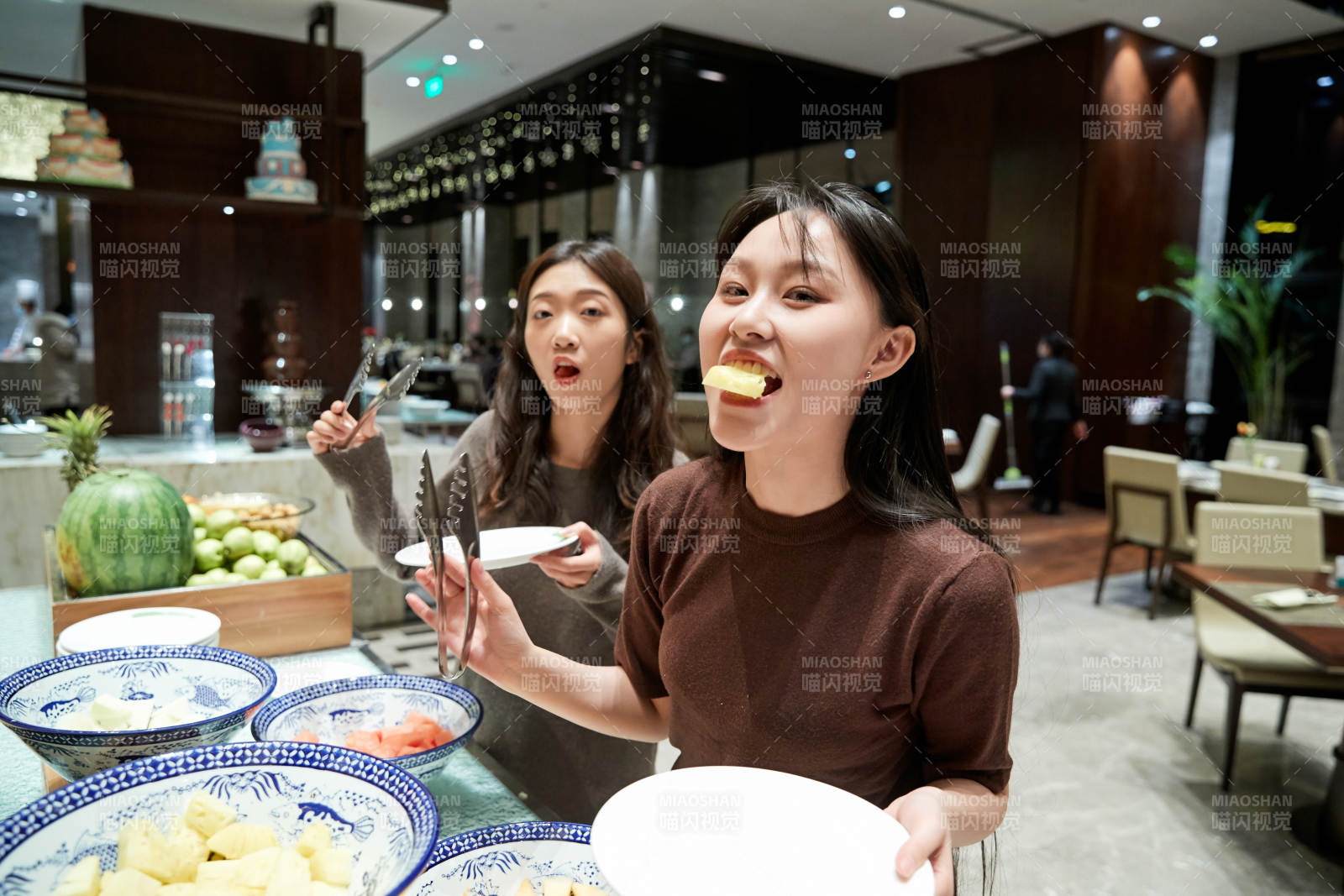 在酒店自助餐廳大吃特吃的亞洲可愛閨蜜少女