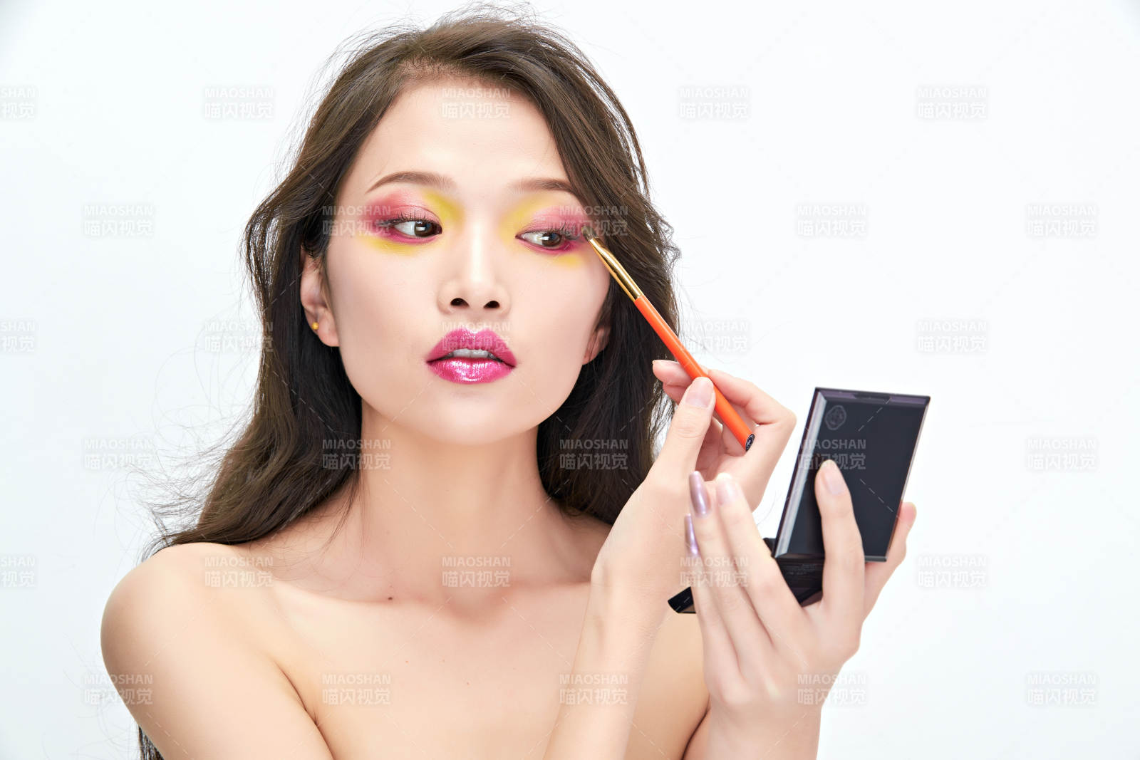 白色背景下棚拍化妝中的美女