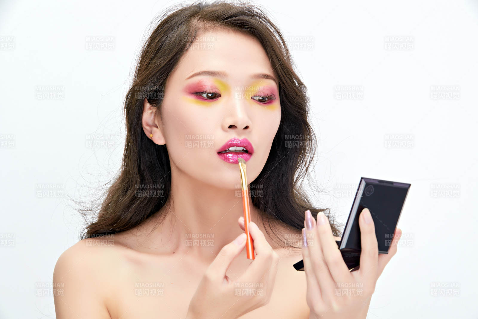白色背景下棚拍化妝中的美女