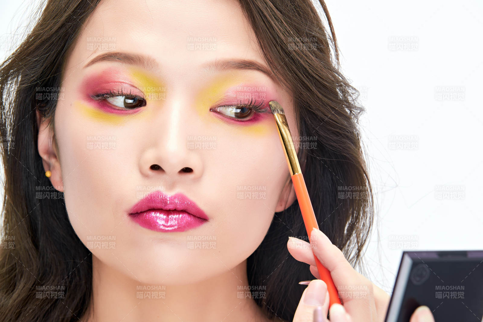 白色背景下棚拍化妝中的美女