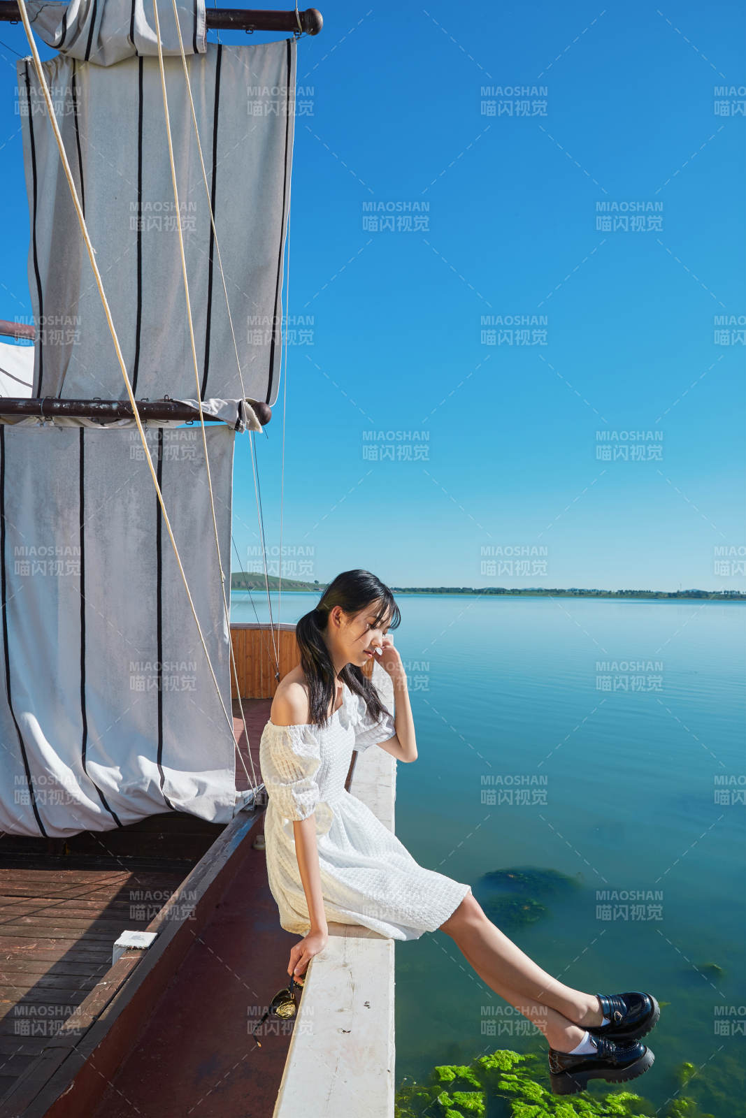 在湖畔木制帆船上的亞洲美女