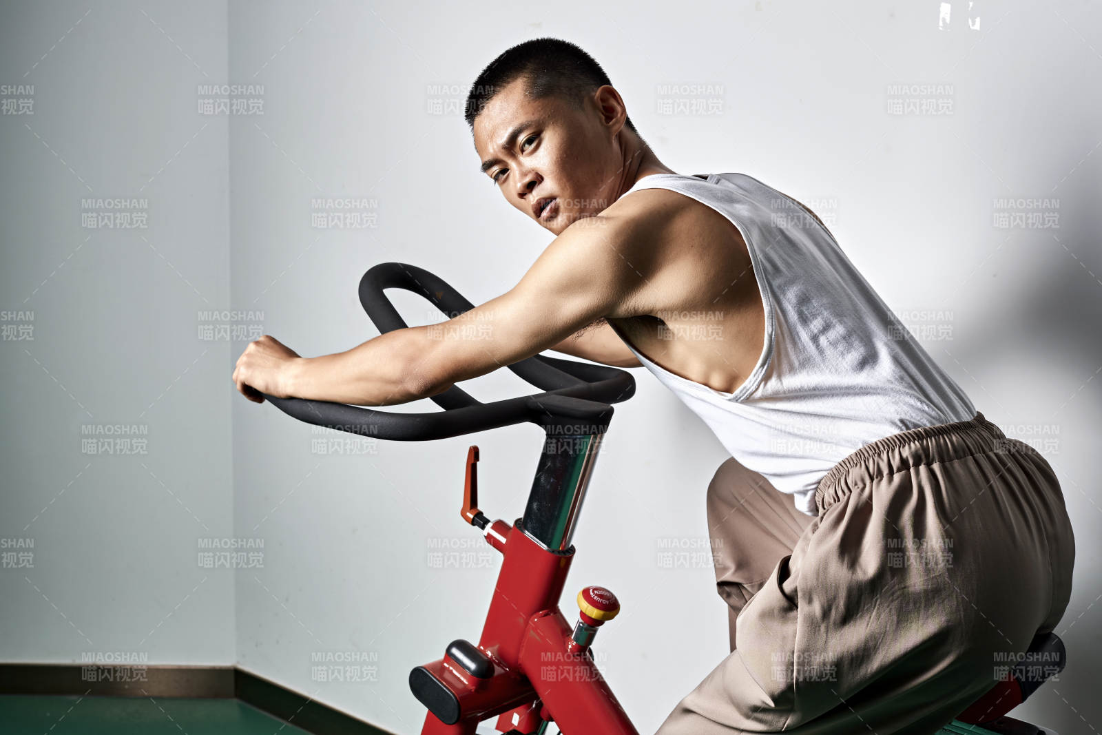 在室內進行動感單車鍛煉的亞洲健身男士形象