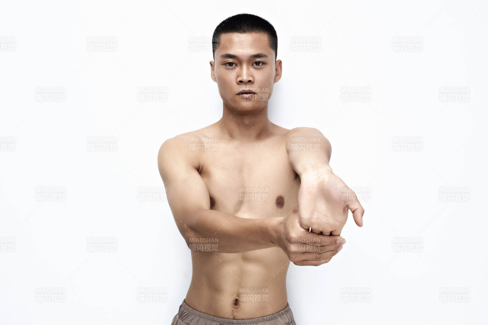 白色背景下展示健身預備拉伸動作的亞洲男性