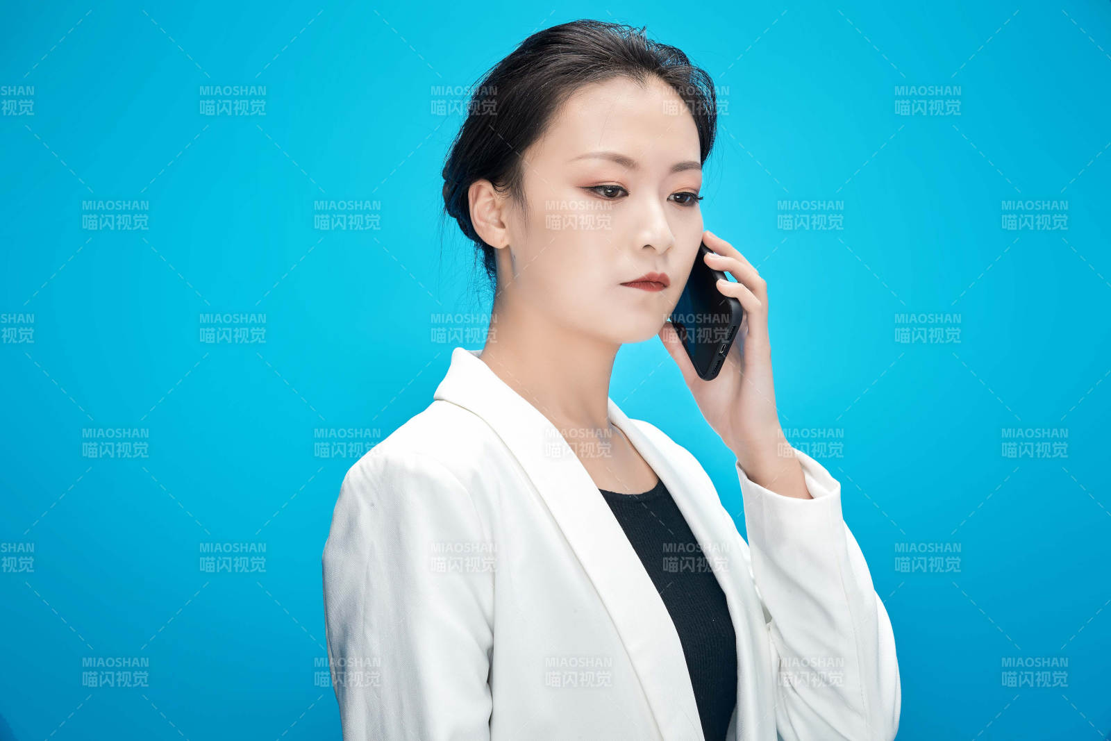 身穿西服拿著手機(jī)與文件夾的亞洲商務(wù)女士