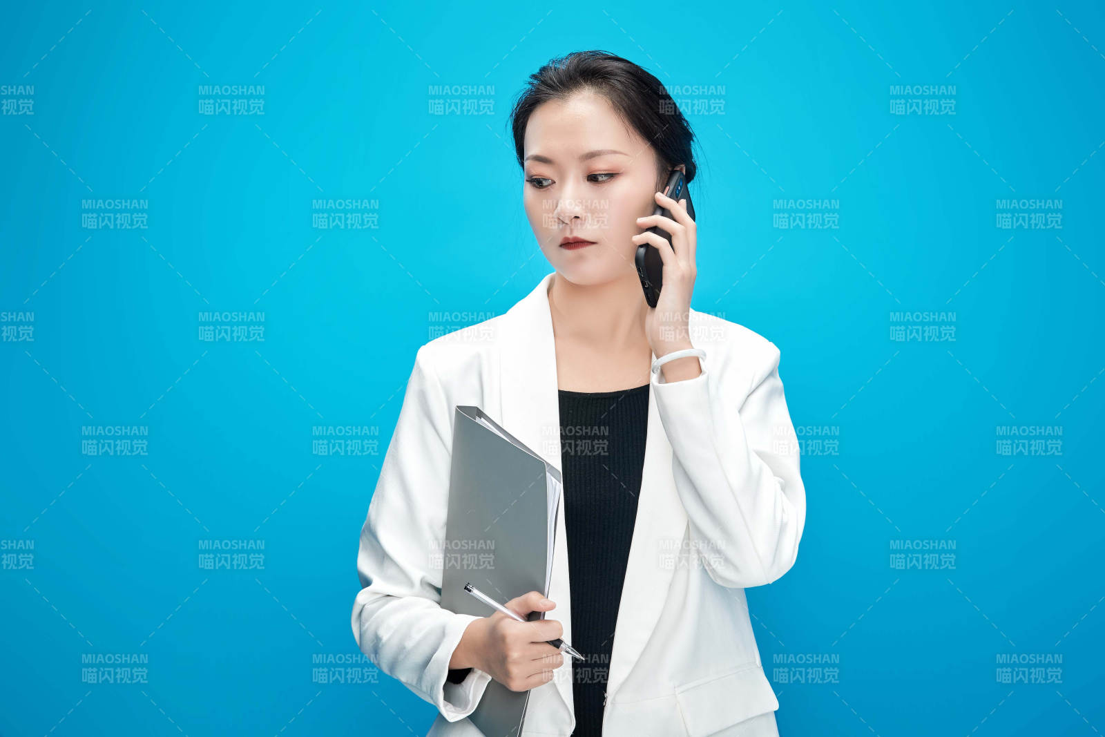 身穿西服拿著手機與文件夾的亞洲商務女士