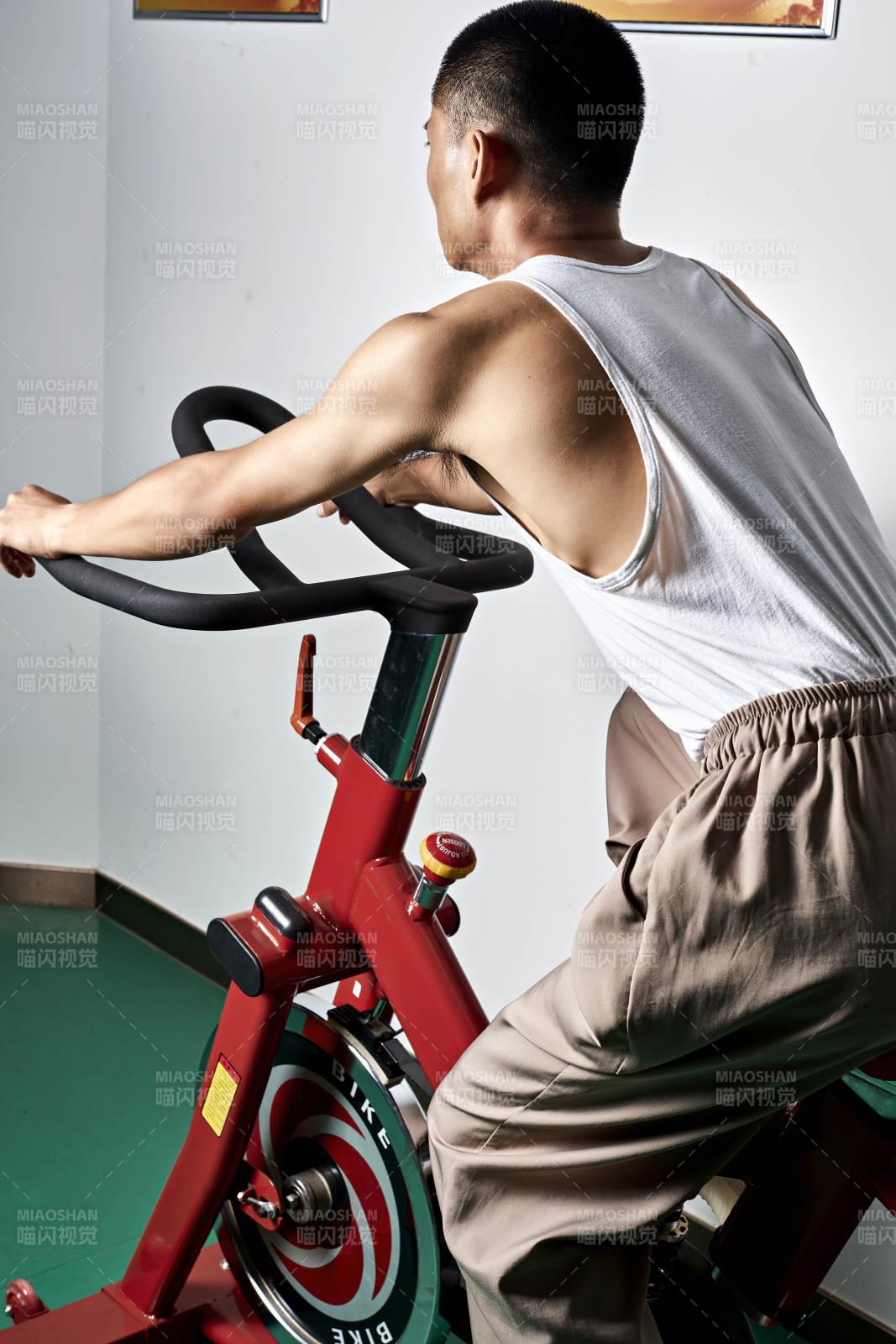 在室內(nèi)進(jìn)行動(dòng)感單車鍛煉的亞洲健身男士形象