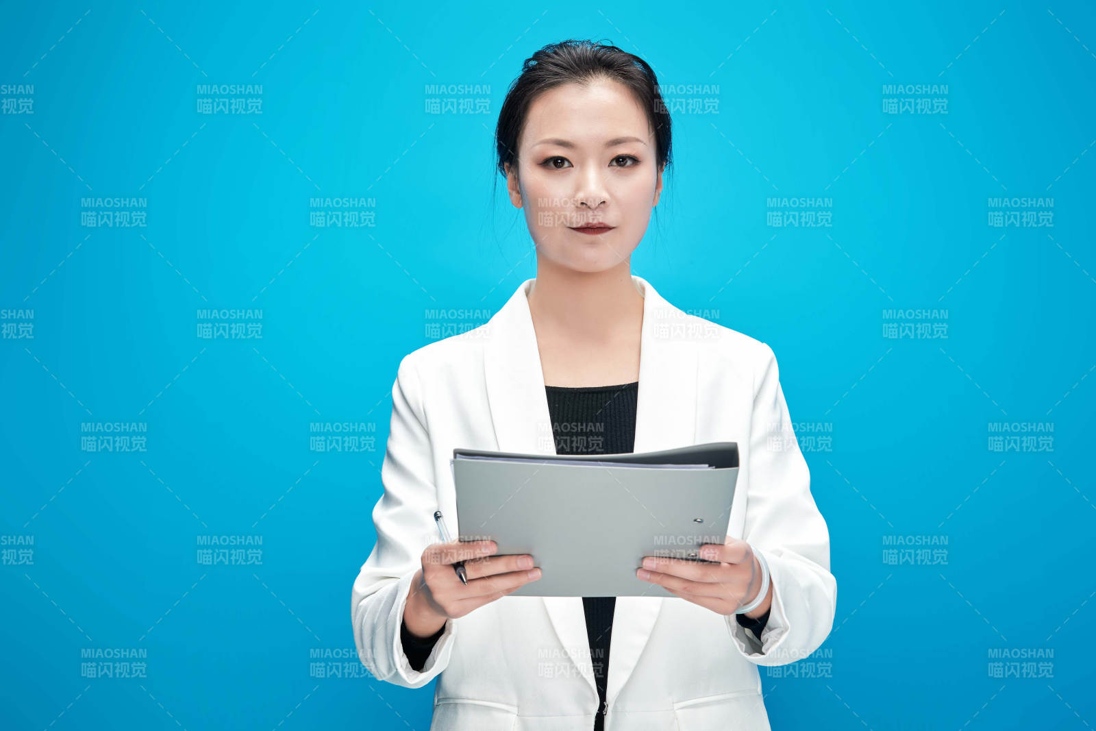 身穿西服拿著手機(jī)與文件夾的亞洲商務(wù)女士